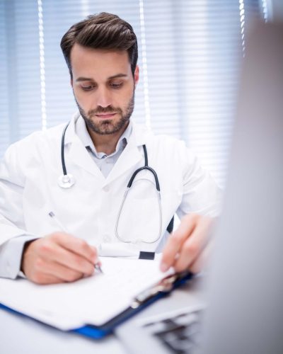 male-doctor-writing-on-clipboard-3AL8UBH (1)